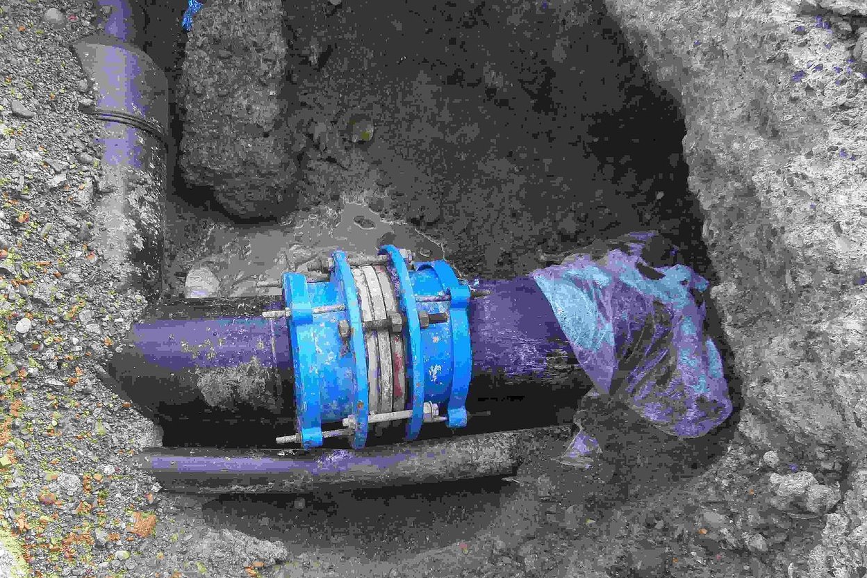 A repaired underground water pipe in an excavated hole