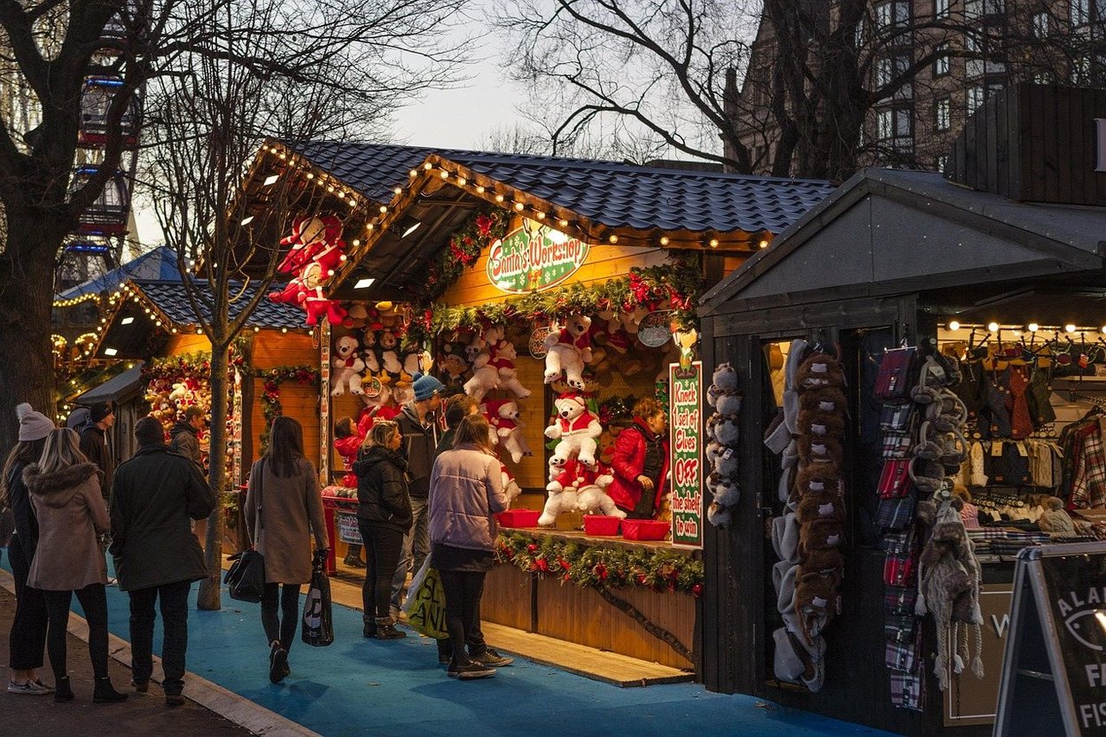 Strings of holiday lights glowing at an outdoor Christmas market at night