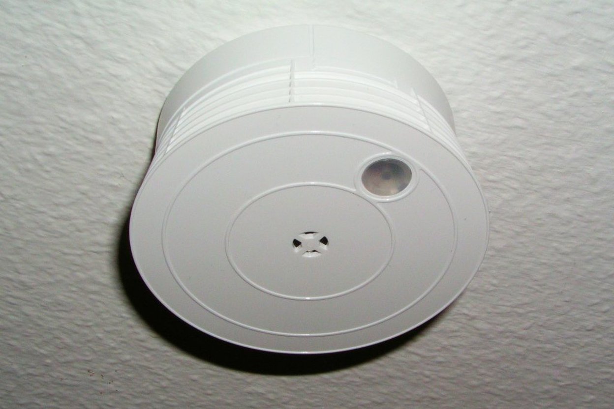A smoke alarm on a ceiling