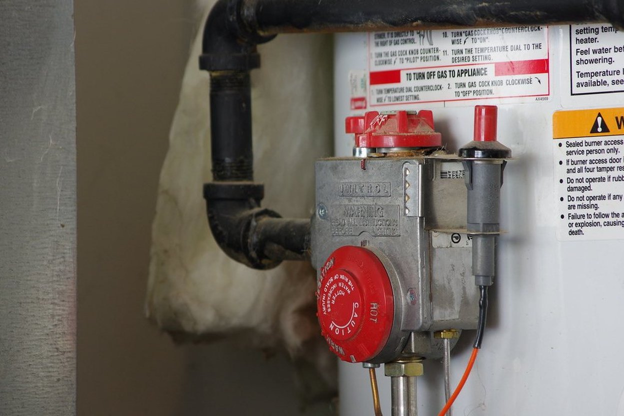 Gas valve and control panel for water heater with safety instructions.