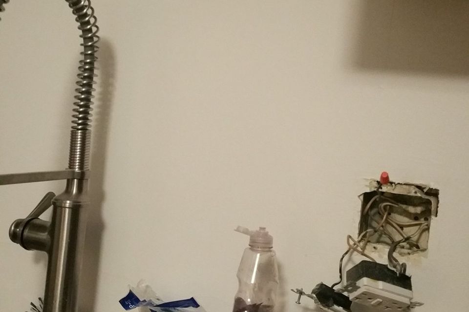 A kitchen outlet beside the sink pulled out of its box for replacement